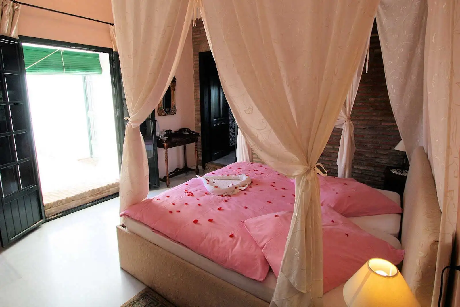 Una habitación con cama de dosel y cortinas de gasa