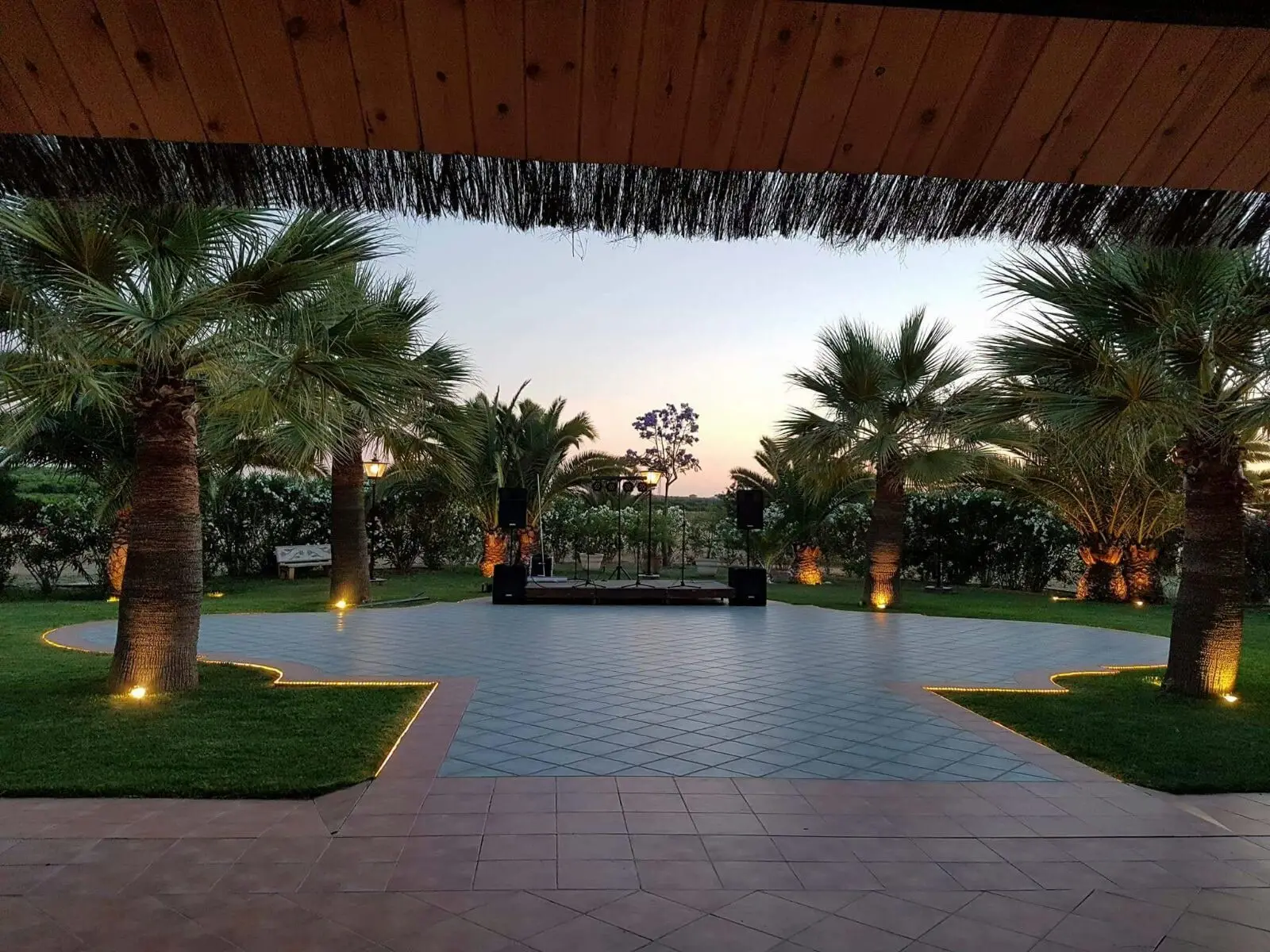 La pista de baile entre palmeras al atardecer, vista desde la terraza cubierta